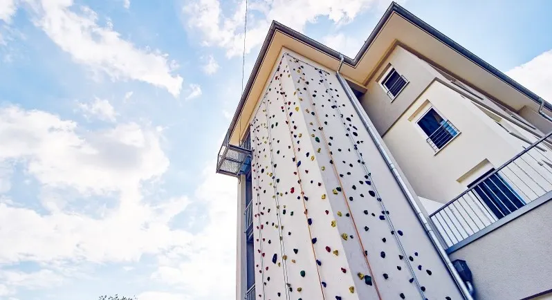Kletterwand an der Fassade eines Gebäudes in Haltern vor blauem Himmel