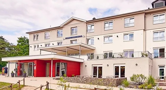 Jugendherberge Haltern am See: heller, mehrgeschossiger Bau mit rotem Eingangsbereich und Terrasse