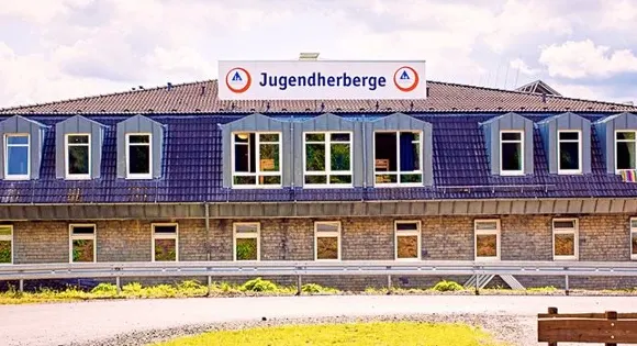 Jugendherberge Sorpesee: langgestrecktes Haus mit Gauben im Schieferdach und dem Schriftzug „Jugendherberge“ auf dem First