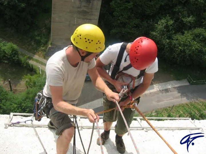 Abseilen am Pfeiler: Zwei Trainer mit Helmen bereiten auf einem Betonpfeiler das Abseilen vor